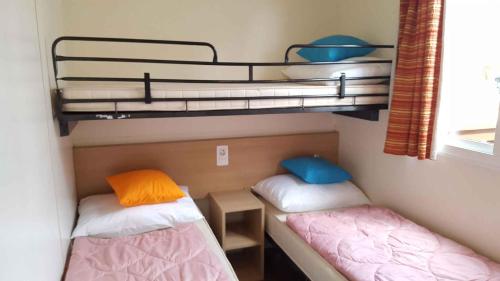 ロザピネタにあるMobilehomes in Rosolina Mare 33791の二段ベッド1組が備わる小さな部屋のベッド2台分です。