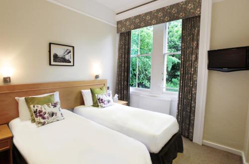 
a hotel room with two beds and a window at Victoria Square Hotel Clifton Village in Bristol
