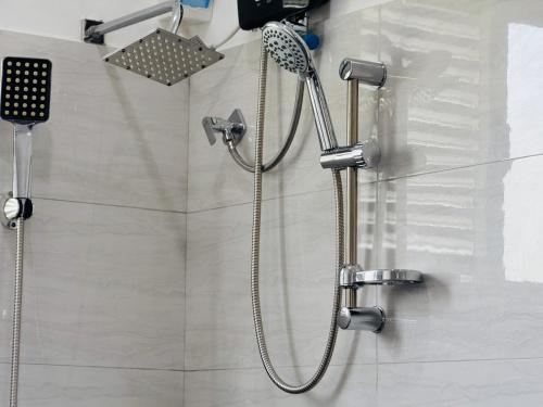 a shower with a shower head in a bathroom at Akarsha Residence in Negombo