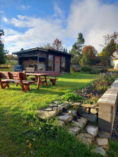 una mesa de picnic y un banco frente a un cobertizo en Apartmán na kopečku, en Pernink