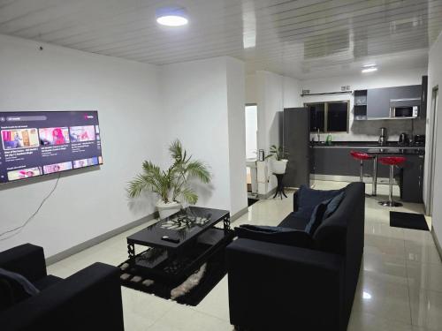 a living room with two couches and a flat screen tv at sarahs apartments solwezi in Mpemba