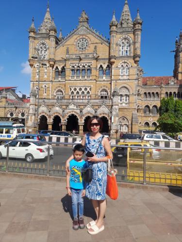 a woman and a child standing in front of a building at Star Holiday in Virār