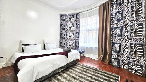 a bedroom with a bed and a window at Jacaranda Escape 4 x King Bed 3 Bath House in Pretoria