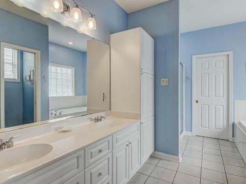 a bathroom with two sinks and a large mirror at Life's a Beach in Tybee Island