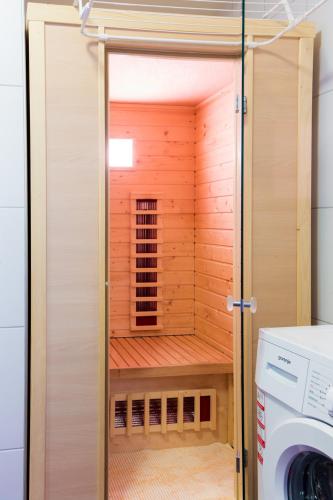 a bathroom with a sauna with a washing machine at Appartement Klosterhügel in Haus im Ennstal