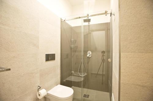 a bathroom with a toilet and a glass shower at Parthenope Suite in Naples