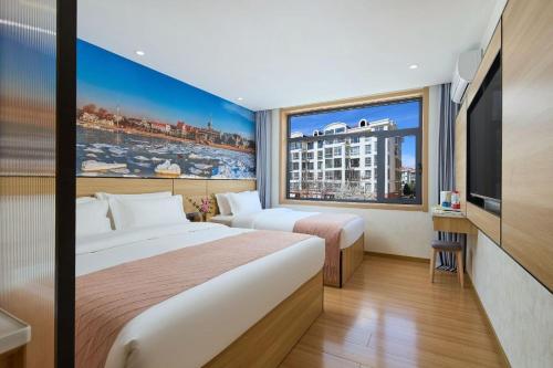 a hotel room with two beds and a large window at Floral Hotel Beidaihe Migao Intelligent Hotel in Qinhuangdao