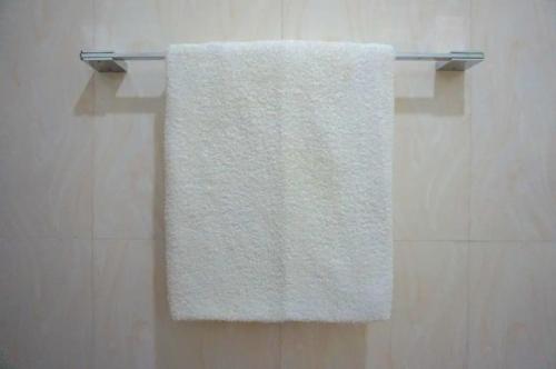 a towel hanging on a towel rack in a bathroom at Barefoot Beach - Hiriketiya in Dickwella