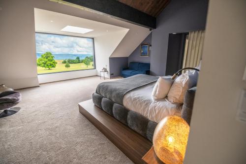 a bedroom with a large bed and a large window at La Maison Bas Lachamp - Luxuary Mountain Villa in Bellefosse