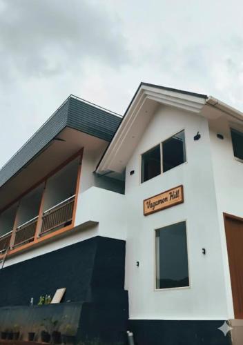 Vagamon Hill Resort في فاغامون: مبنى ابيض عليه لافته