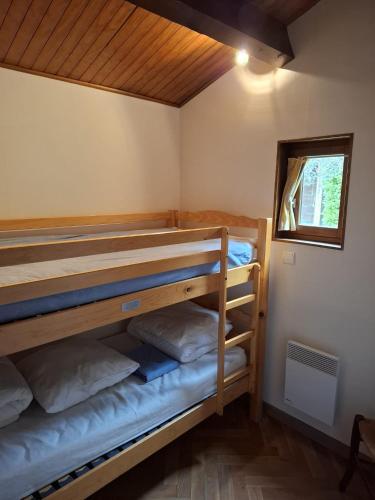 a bunk bed room with two bunk beds and a window at Les Chalets du Roc in Alzon