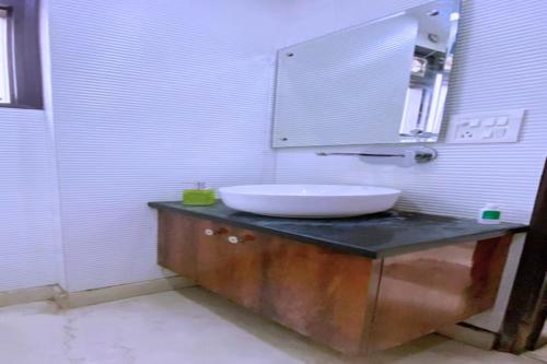 a bathroom with a sink and a mirror at Cassava Stay close to Visa Center in New Delhi