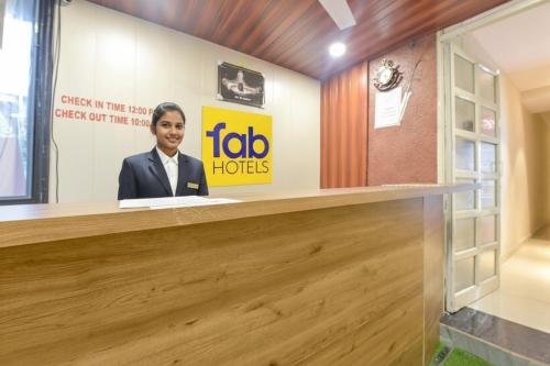 Una mujer está sentada en un mostrador de recepción. en Via The Max Glory, en Indore