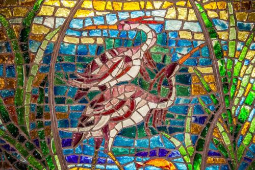 a stained glass picture of two birds in the woods at Perdido Beach Resort in Orange Beach