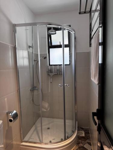 a shower with a glass door in a bathroom at Namelok apartment in Sekenani
