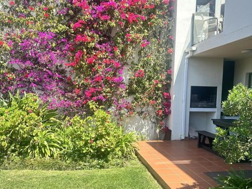 a wall with pink flowers on the side of a building at No. 1 Arrowood, Plettenberg Bay in Plettenberg Bay