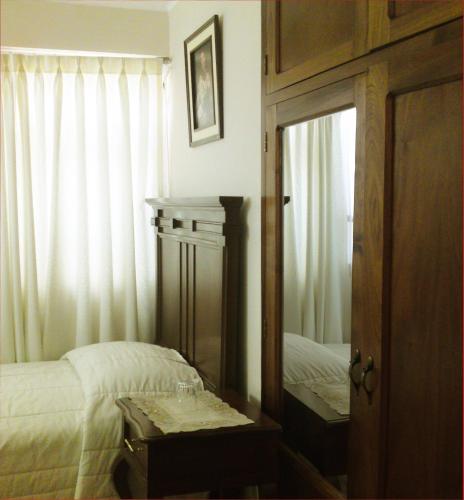 a bedroom with a mirror next to a bed at San Marino Royal Hotel in Sucre