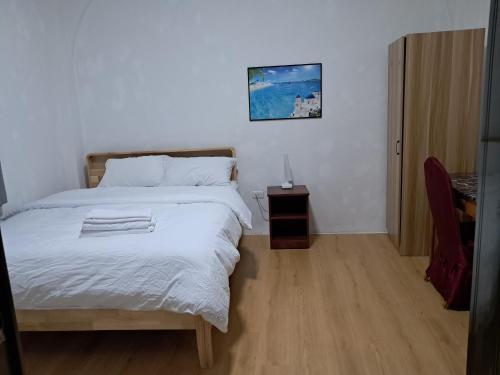 a bedroom with a bed and a table with a lamp at Tinian Lucky Home in Tinian