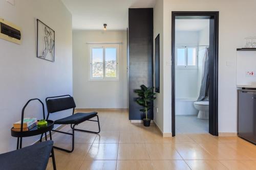 a living room with a table and a chair and a toilet at estéa - Peyia's Pearl - Holiday Studio in Peyia