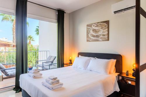 a bedroom with a bed with towels on it at estéa - Peyia's Pearl - Holiday Studio in Peyia