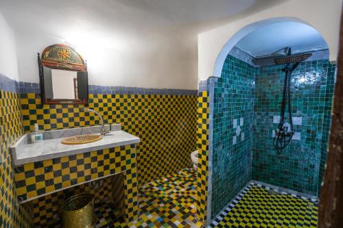 a bathroom with a yellow and blue checkered tiles at Dar Elinor Fez in Fès