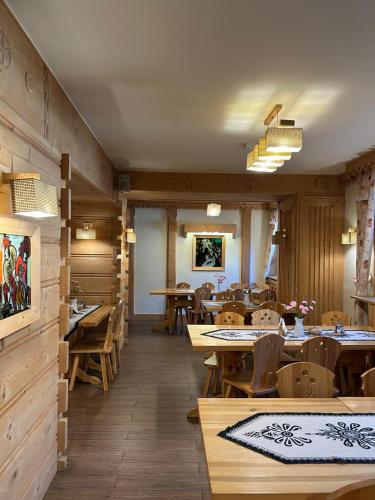 een restaurant met houten tafels en houten stoelen bij Pensjonat Jastrzębia Turnia in Zakopane