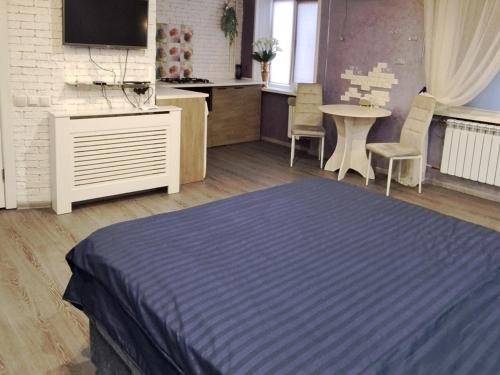 a bedroom with a bed and a table with chairs at Студия в центре города in Kryvyi Rih