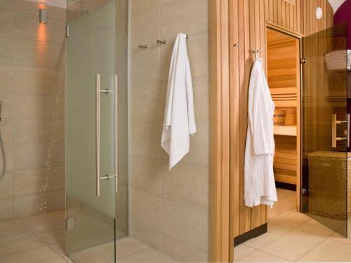 a bathroom with a shower with a glass door at Mercure Grand Hotel Biedermeier Wien in Vienna