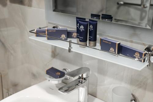 a bathroom with a sink and a shelf with books at Bogishamol Hotel in Andijan