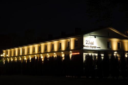 a building lit up at night with lights at Hotel Carskie Koszary in Zamość