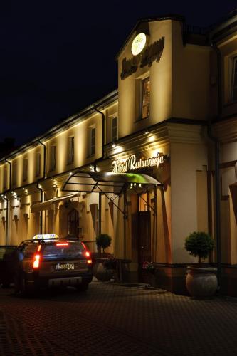 a car parked in front of a building at night at Hotel Carskie Koszary in Zamość