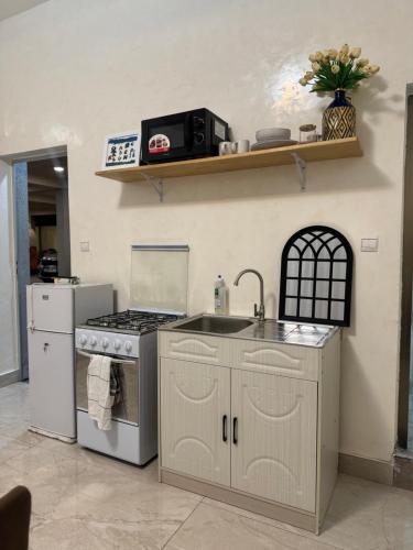 ブラザヴィルにあるEpayinayocgのコンロとシンクのあるキッチン