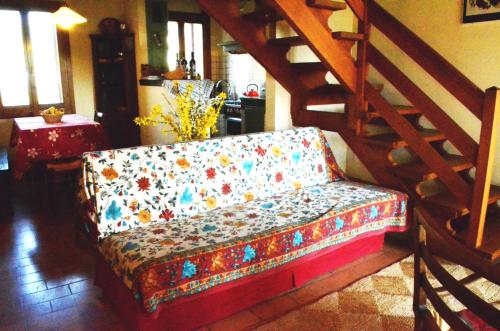 un sofá sentado en una sala de estar junto a una escalera en agriturismo Cà Roer, en San Zenone