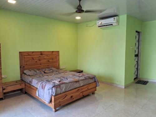 Un dormitorio con una cama en una habitación con paredes verdes. en Best and biggest place to have quality time, en Malavli