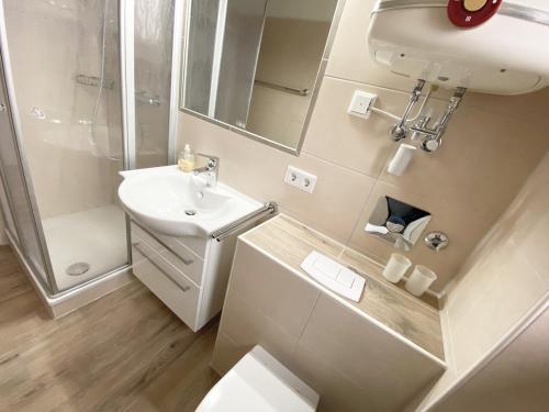 een badkamer met een wastafel, een toilet en een douche bij Ruhige See in Borkum