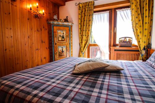 a bedroom with a bed with a checkered blanket at Nido Ampezzano - a short walk from the center in Cortina dʼAmpezzo