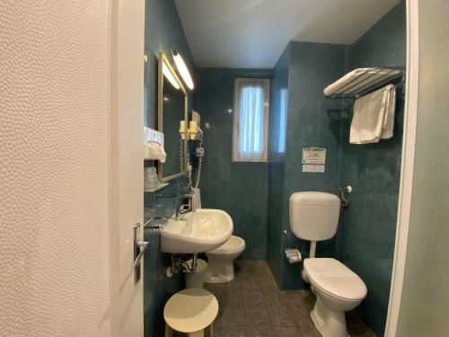 Un baño con dos inodoros y un lavabo. en Sleep Al 25, en Finale Ligure