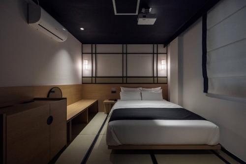 a small bedroom with a bed and a desk at Mitasuya Ryokan Hotel Daejeon Yongjeon in Daejeon
