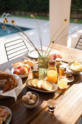 a wooden table with breakfast foods on it at Cielo villas - An Authentic Mediterranean Living in Zakynthos Town