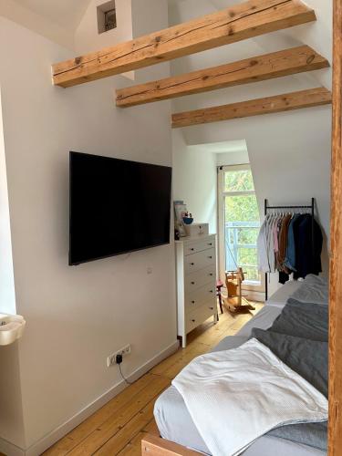 a bedroom with a flat screen tv on the wall at Cityapartment am historischen Wall in Aurich