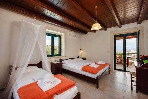 Un dormitorio con dos camas y un balcón. en Villa Dionysos - Kalamaki Holidays, en Kamilari