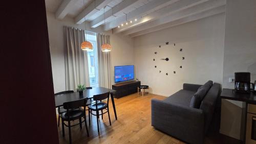 a living room with a couch and a table and a television at BG Time in Bergamo