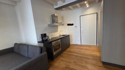 a living room with a couch and a kitchen at BG Time in Bergamo