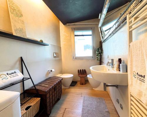 Un baño con lavabo, inodoro y ventana. en Bilocale centralissimo a due passi dal mare - CN023, en Cesenatico