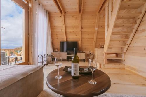 een kamer met een bed en twee wijnglazen op een tafel bij Komovi Luxury Sunset in Andrijevica