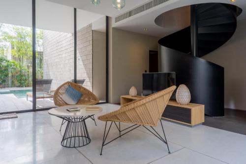 a living room with chairs and a table and a tv at Oceanphere Villa by Prop Hopper in Bang Sare