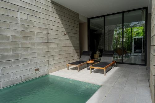 a patio with two chairs and a swimming pool at Oceanphere Villa by Prop Hopper in Bang Sare