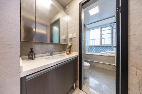 深セン市にある岗厦汇花园行政公寓酒店-深圳福田会展中心岗厦地铁站店の洗面台、トイレ、鏡のあるバスルーム