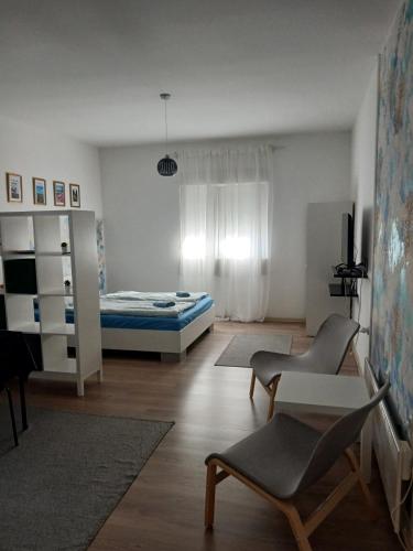 a living room with a bed and a table and chairs at Apartman Centar Surcin in Surčin