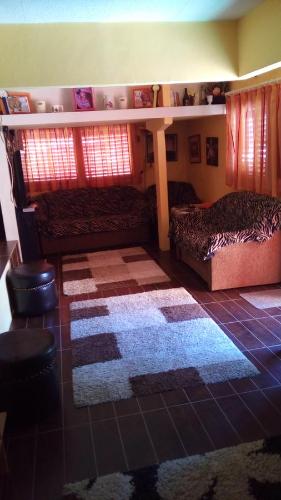 a bedroom with two beds and a rug at Judit nyaraló in Velence